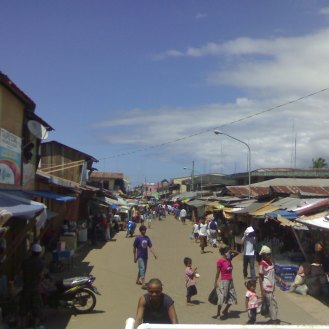 Tausug south/southeast: Main road at Port Holland, Maluso, Basilan, flanked by Tausug traders and market stall owners.